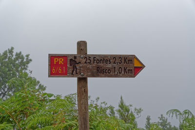 Low angle view of information sign against sky