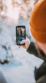 Cropped hand of woman using mobile phone