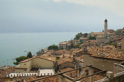 High angle view of townscape by sea against sky