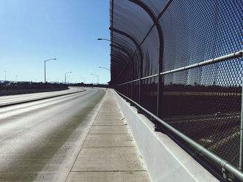 Empty road against sky in city