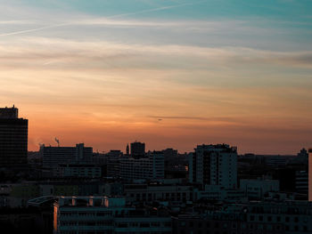 Modern buildings against sky during sunset