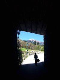 Rear view of silhouette man walking in tunnel