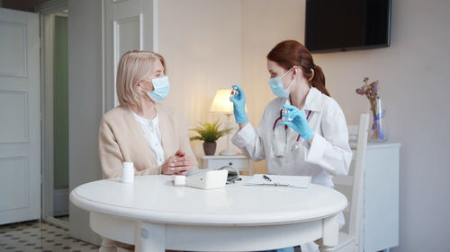 Side view of female doctor examining patient in bathroom