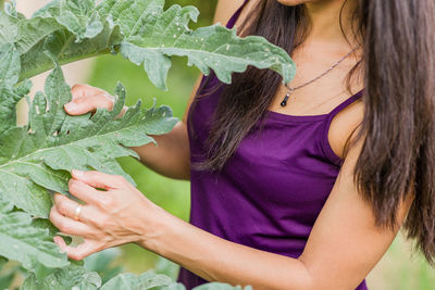 Midsection of woman holding leaves
