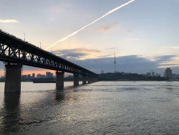 Bridge over river against sky during sunset