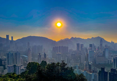 Buildings in city against sky during sunset