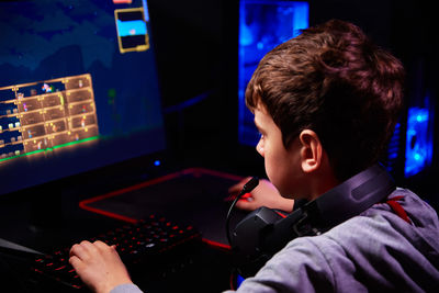 Boy plays computer game at home, gaming addiction