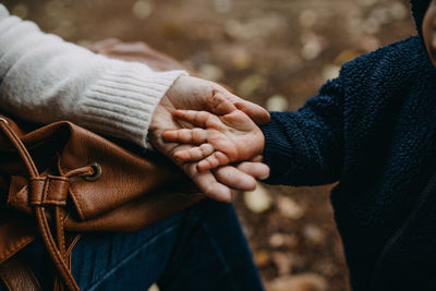 Midsection of couple holding hands during winter