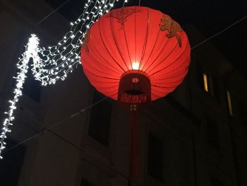 Low angle view of illuminated lanterns hanging at night