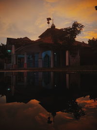 Reflection of building on lake during sunset