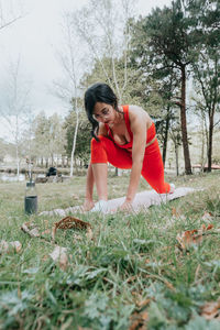 Side view of woman sitting on field