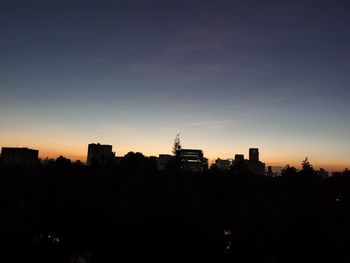 Silhouette buildings against sky during sunset