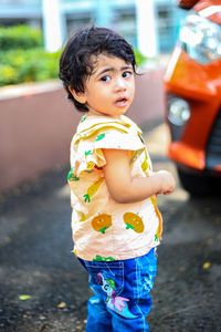 Cute boy looking down while standing outdoors