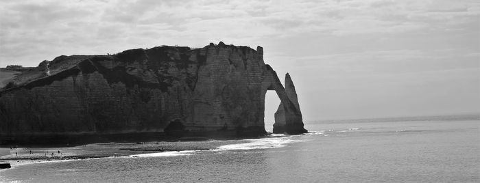 Rock formation on beach against sky