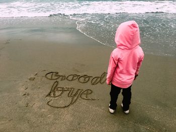 Rear view of woman standing on beach