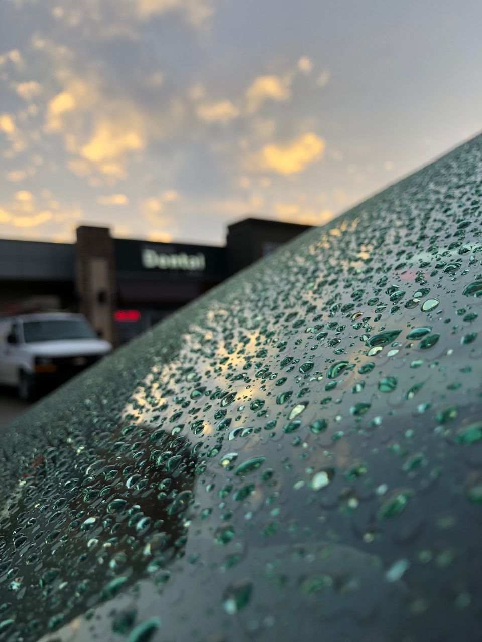 CLOSE-UP OF RAINDROPS ON CAR WINDSHIELD