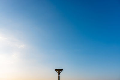 Low angle view of street light against blue sky