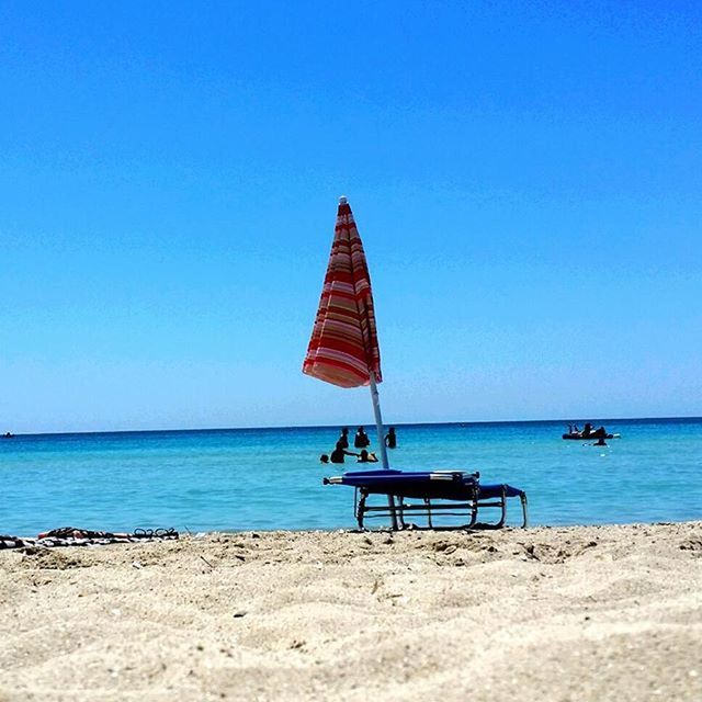 sea, horizon over water, beach, water, clear sky, blue, tranquility, tranquil scene, shore, sand, copy space, scenics, beach umbrella, beauty in nature, nature, absence, vacations, idyllic, parasol, nautical vessel