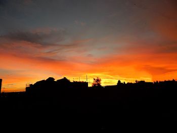 Silhouette buildings against sky during sunset