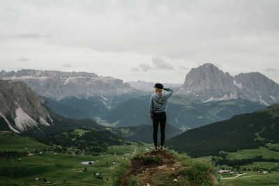 Woman standing on top of the rock overlooking the mountains