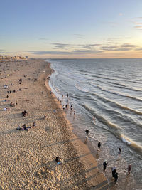 High angle view of people on beach against sky during sunset