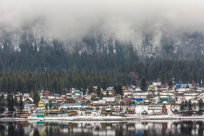 Scenic view of lake by trees and buildings