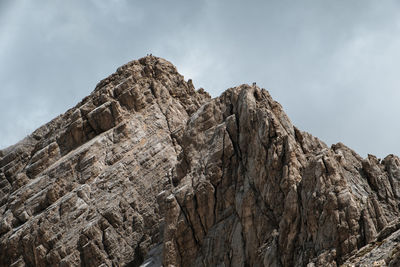 Low angle view of rocky mountains against sky