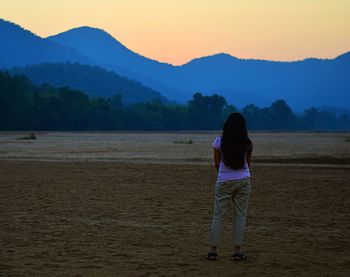 Rear view of a woman standing on landscape