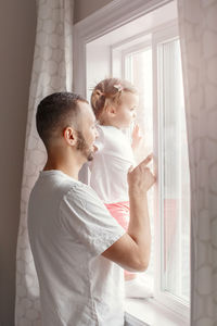 Father showing while pointing at window to daughter