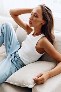 Young woman sitting on sofa at home