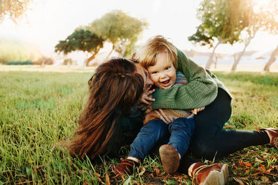 Mother and daughter sitting on field