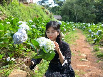 Portrait of girl holding flowering plants