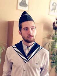 Young man in uniform looking away while at home