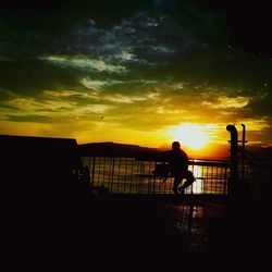 Silhouette men standing against sky during sunset