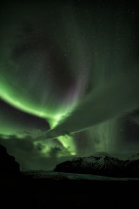 Scenic view of snowcapped landscape against sky at night