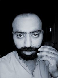 Portrait of young man wearing sunglasses against black background
