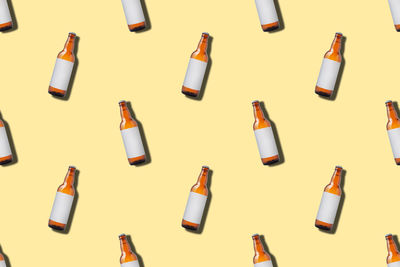 Beer bottle seamless pattern on yellow background