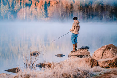 Full length of man standing by lake