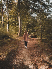 Rear view of woman walking in forest