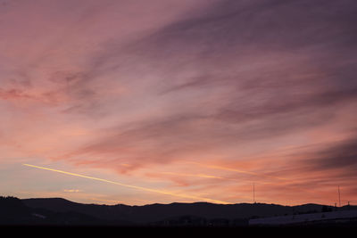 Low angle view of silhouette mountain against dramatic sky