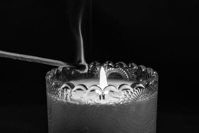 Close-up of lit candle against black background