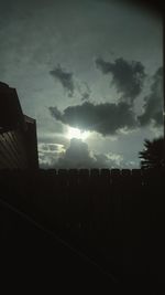 Silhouette of building against cloudy sky