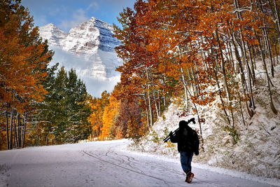 Rear view of man standing on snow covered mountain