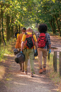 Volunteers of multinational group go into the forest with bags for collecting and recycling garbage