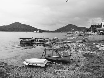 Boat moored on shore against sky