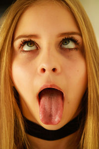 Close-up of young woman sticking out tongue