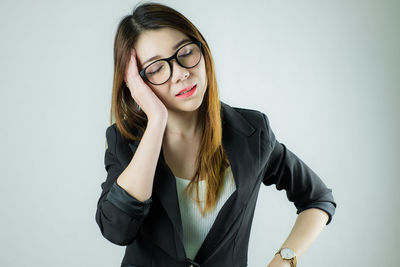 Portrait of beautiful young woman against gray background