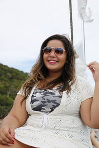 Young woman wearing sunglasses against sky