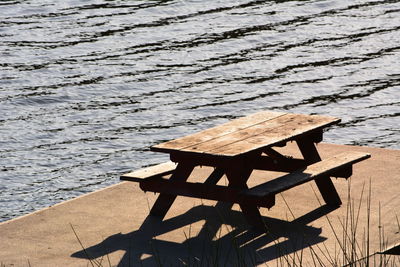 High angle view of wooden table on pier at lake