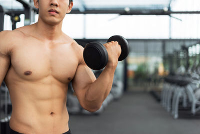 Shirtless man exercising at gym